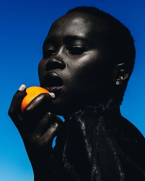 Black woman eating an orange