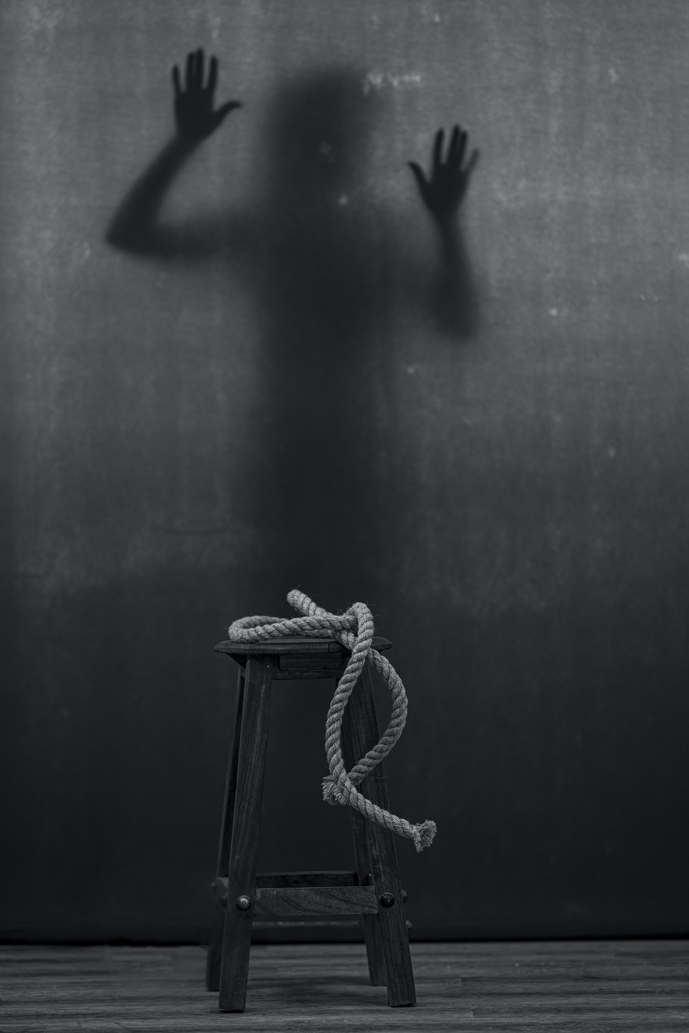 silhouette in front of a stool and rope