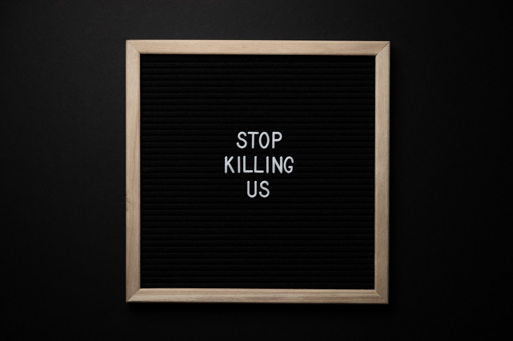 sign with stop killing us